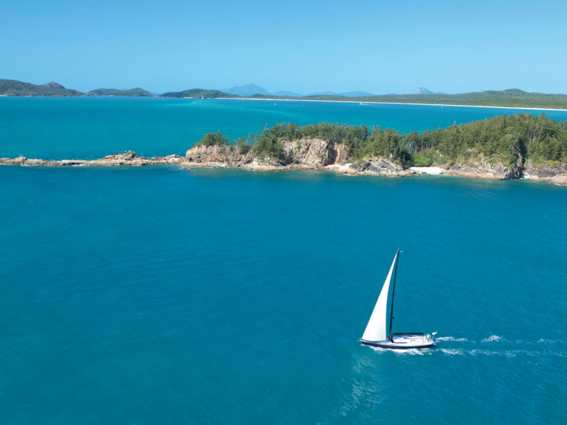 A vessel under sail at Tongue Point near Whitehaven Beach